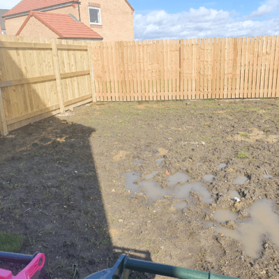 A waterlogged muddy garden before we installed artificial grass
