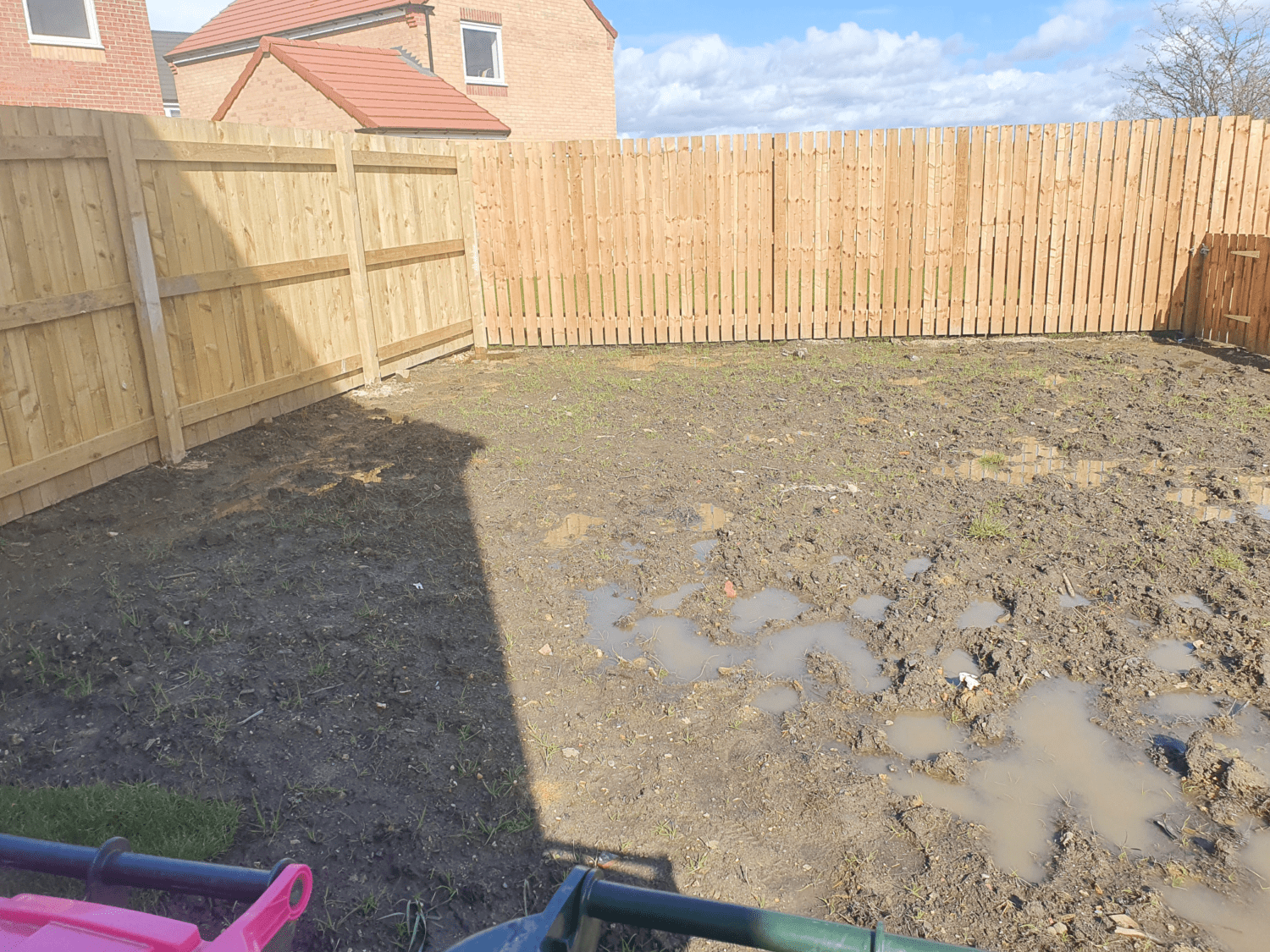 A waterlogged muddy garden before we installed artificial grass