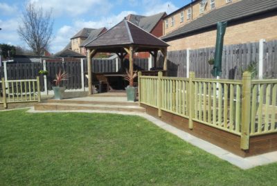 Photo of a corner decking installation with fencing & a solid roof gazebo