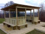 Timber Meadow Outdoor Classroom with boarded felt roof, timber fencing, and built-in seating for schools.