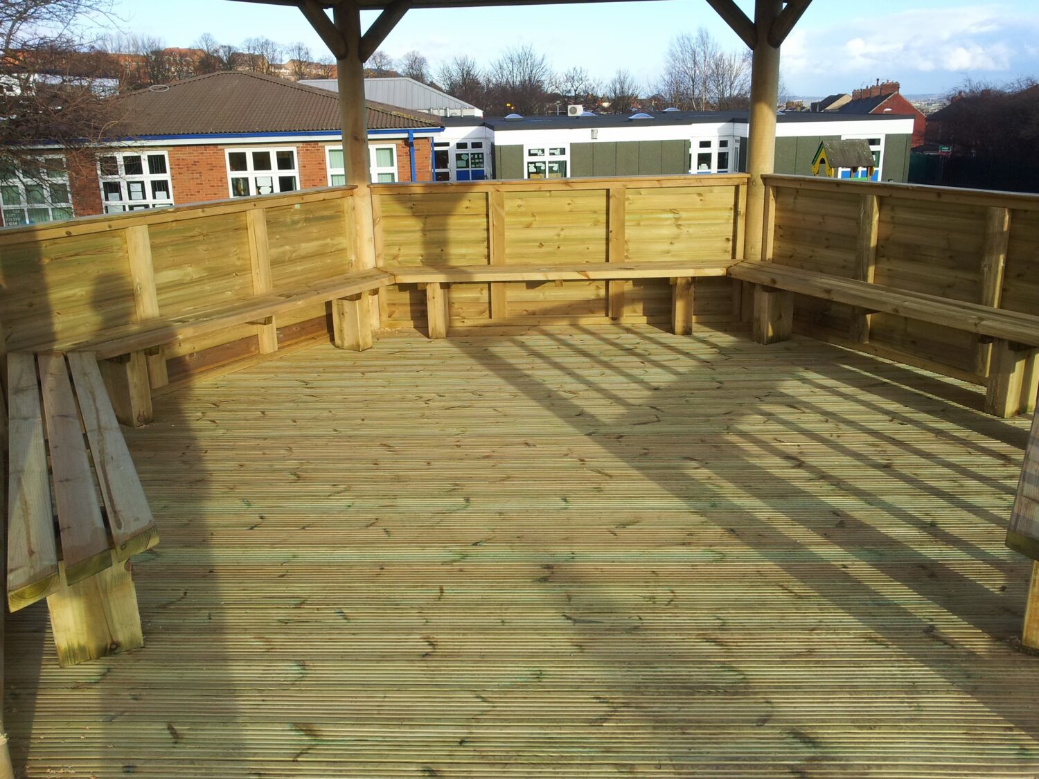 Inside view of Classic Timber Roof Gazebo showing tanalised decking base and built-in bench seating for schools.