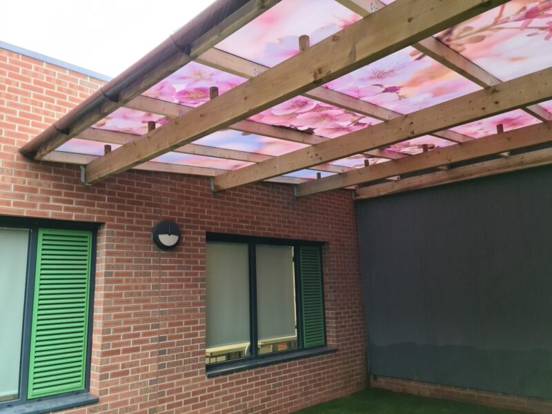 Fountaindale LightPrint Vinyl Canopy with cherry blossom printed vinyl design installed on polycarbonate shelter panels.